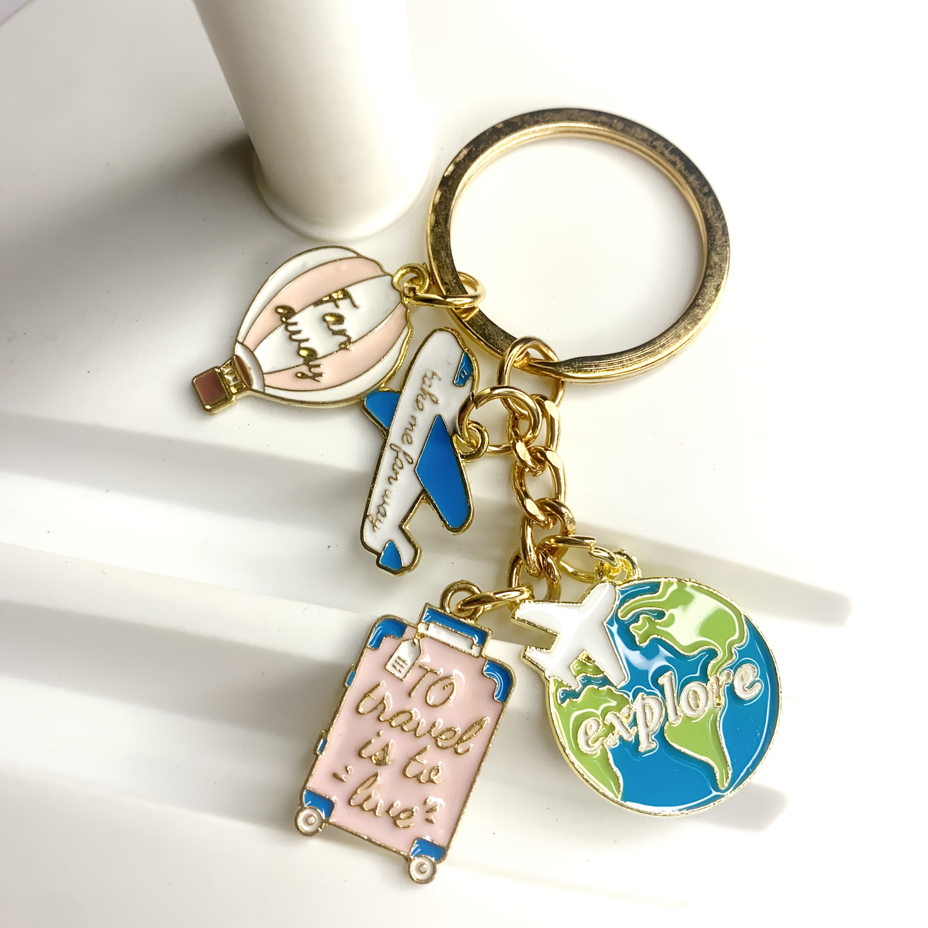 Image of A Stylish Travel-themed Keychain Design With Airplanes, Suitcases, Globes, And Balloons, Making It For Travelers And Ideal As An Accessory And Charm For Bags And Car Keys