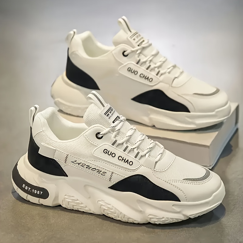 1 par de zapatos de skate versátiles para hombre con agarre fuerte, adecuados para viajes y caminatas al aire libre, comodidad para todas las estaciones, zapatillas bajas con cordones casuales en blanco y negro.