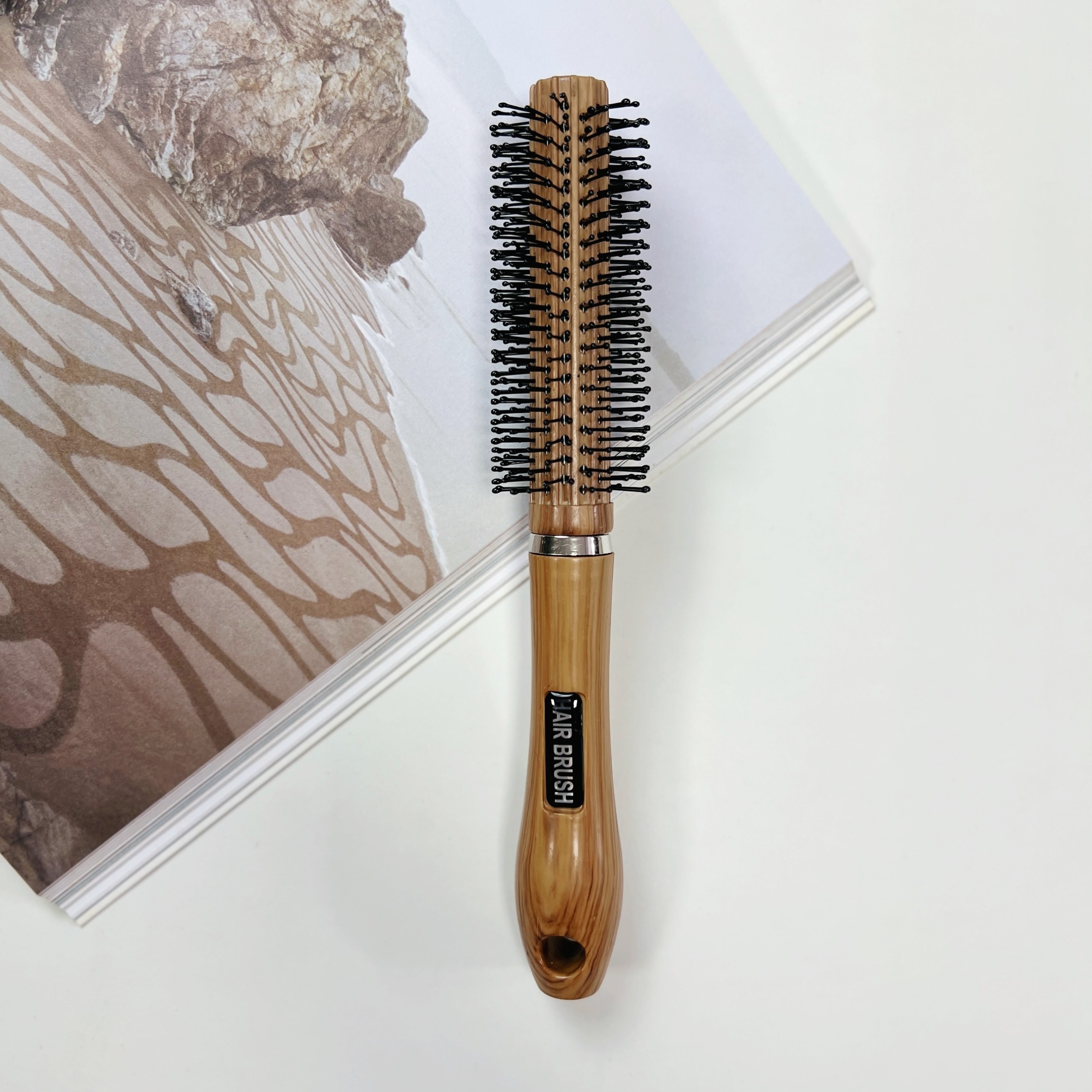 E-shop Ein zylindrischer Kamm im Holzmaserung-Design mit hochwertigen Zähnen zum Schaffen von welligen Locken und zur Haarveredelung. Geeignet für alle