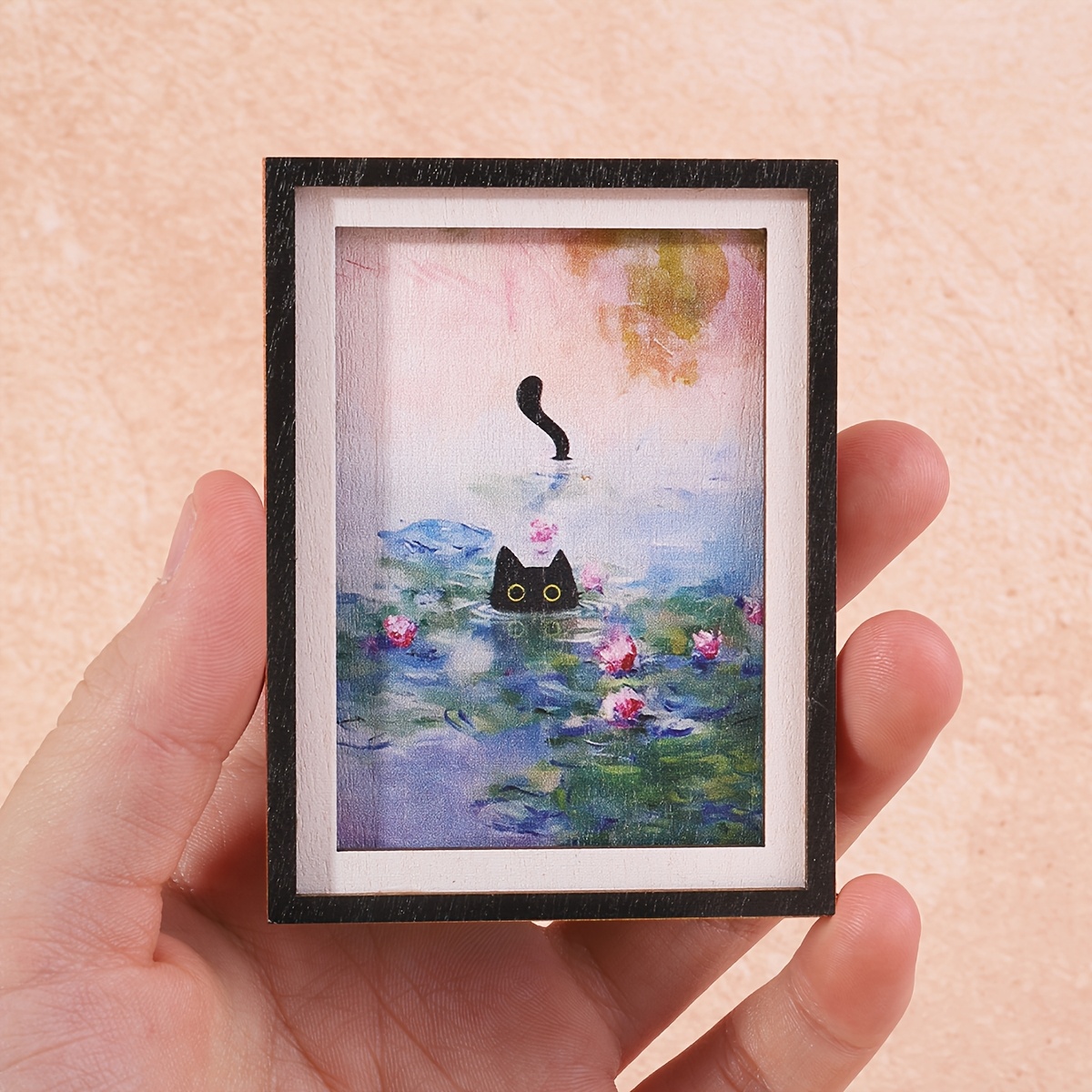 E-shop Ein Mini-Kühlschrankmagnet in Bilderrahmenform mit einer kleinen schwarzen Katze, die im Blumenweiher schwimmt, ein wundervoller Deko-Artikel,