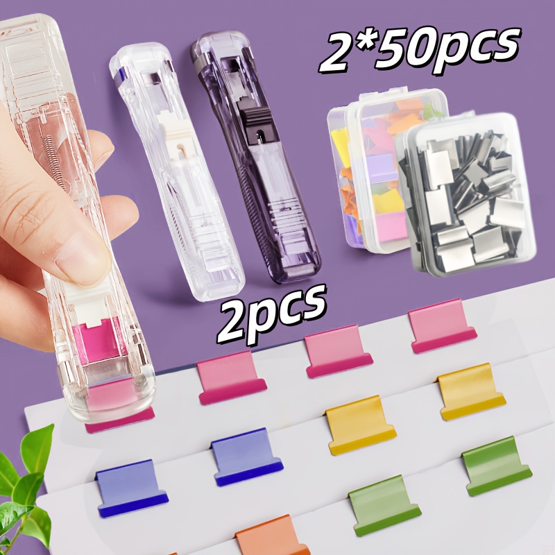 E-shop Schwarz-weißes zweiteiliges Set wiederverwendbarer Mini-Handklammerdruckstreifmaschinen, inklusive 50 farbiger und 50 silberner Nachfüllclips,