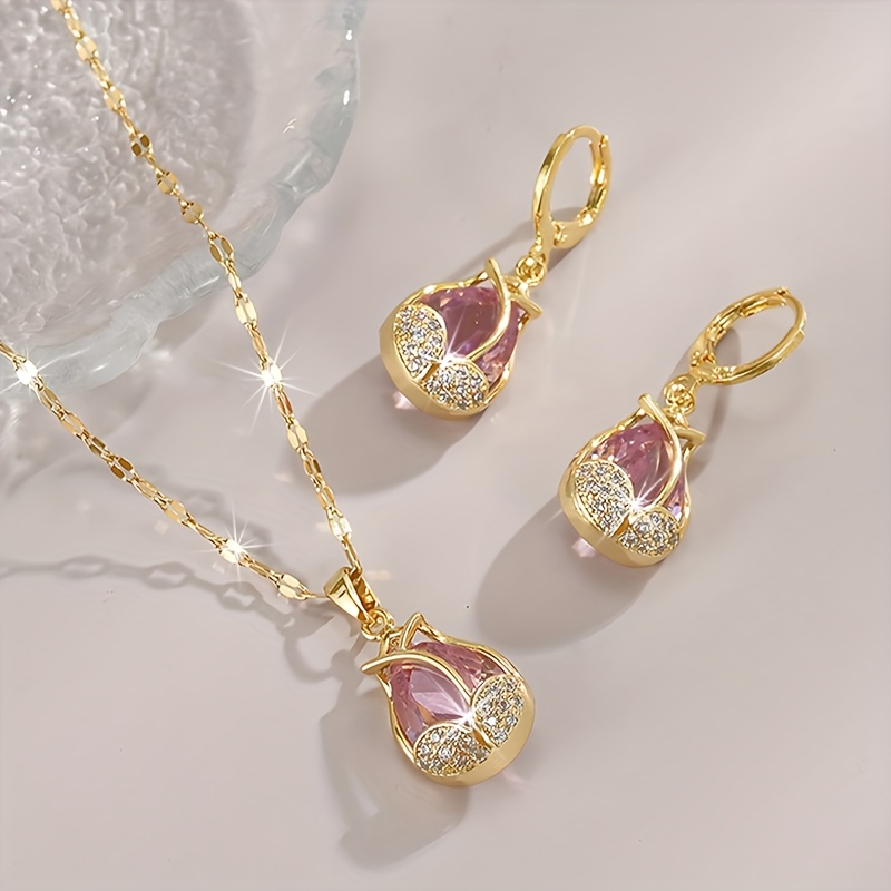 E-shop Eine vergoldenete Halskette mit funkelnden quadratischen Kristallen und rosa Tulpen für Damen, zusammen mit einem Paar passenden Ohrringen. Die