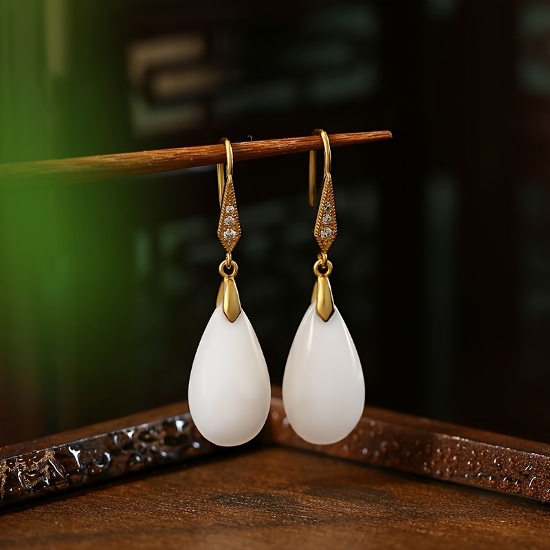A Set Of Stylish White Dangling Earrings With A Gold-plated Classic Pendant Design, Perfect For Women's Fashion Additions And As A Gift Option