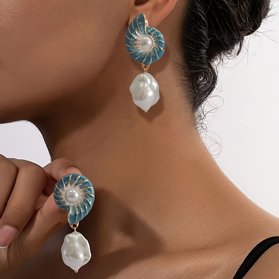 

A Pair Of Elegant Ocean-themed Drop Earrings For Women Featuring Blue Acrylic Seashells With And Irregular Pearl Pendants, Wear And Vacations.