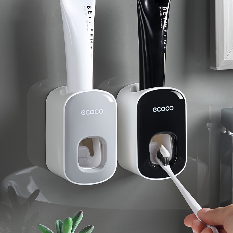 Automatic wall-mounted toothpaste squeezer for home use.