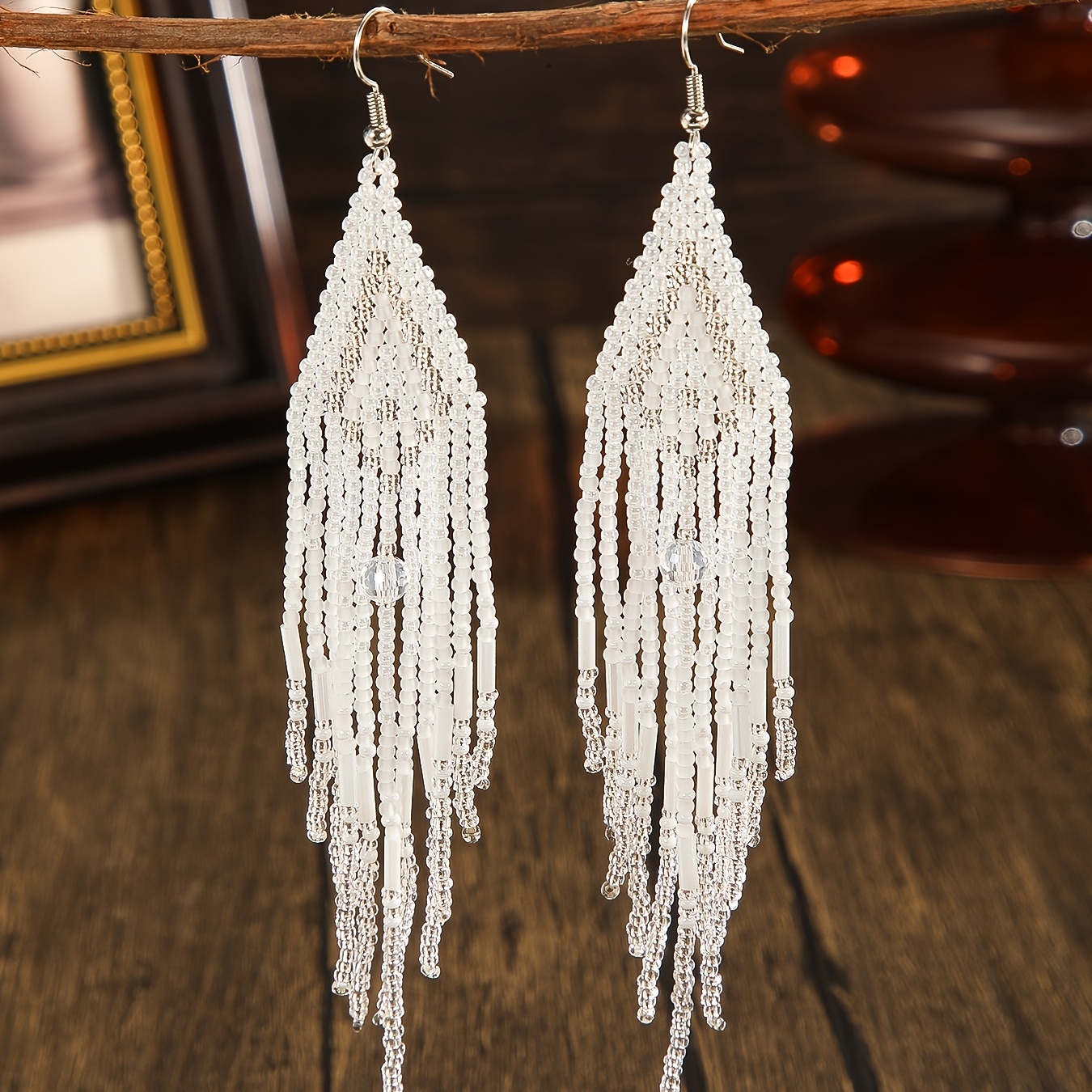 E-shop Ein Paar modische, lange, fließende Quasten, elegante Ohrringe für Damen, im Bohemian-Stil mit weißen, geometrischen Farbverlauf-Verzierungen.