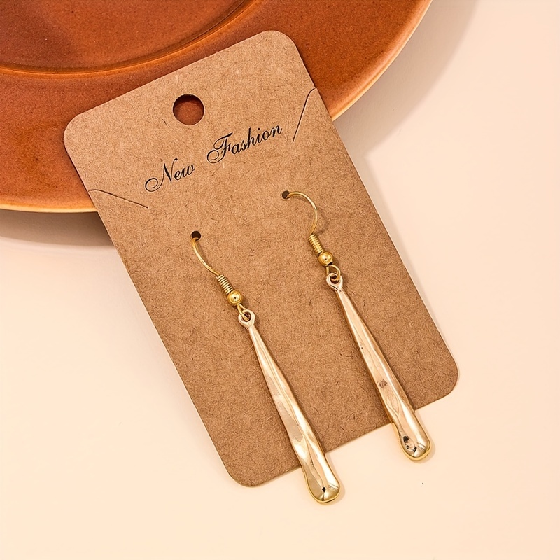 A Pair Of Long Geometric Pendant Earrings With Irregular Pleated Strips, Featuring A Metallic Texture And Fashion Style