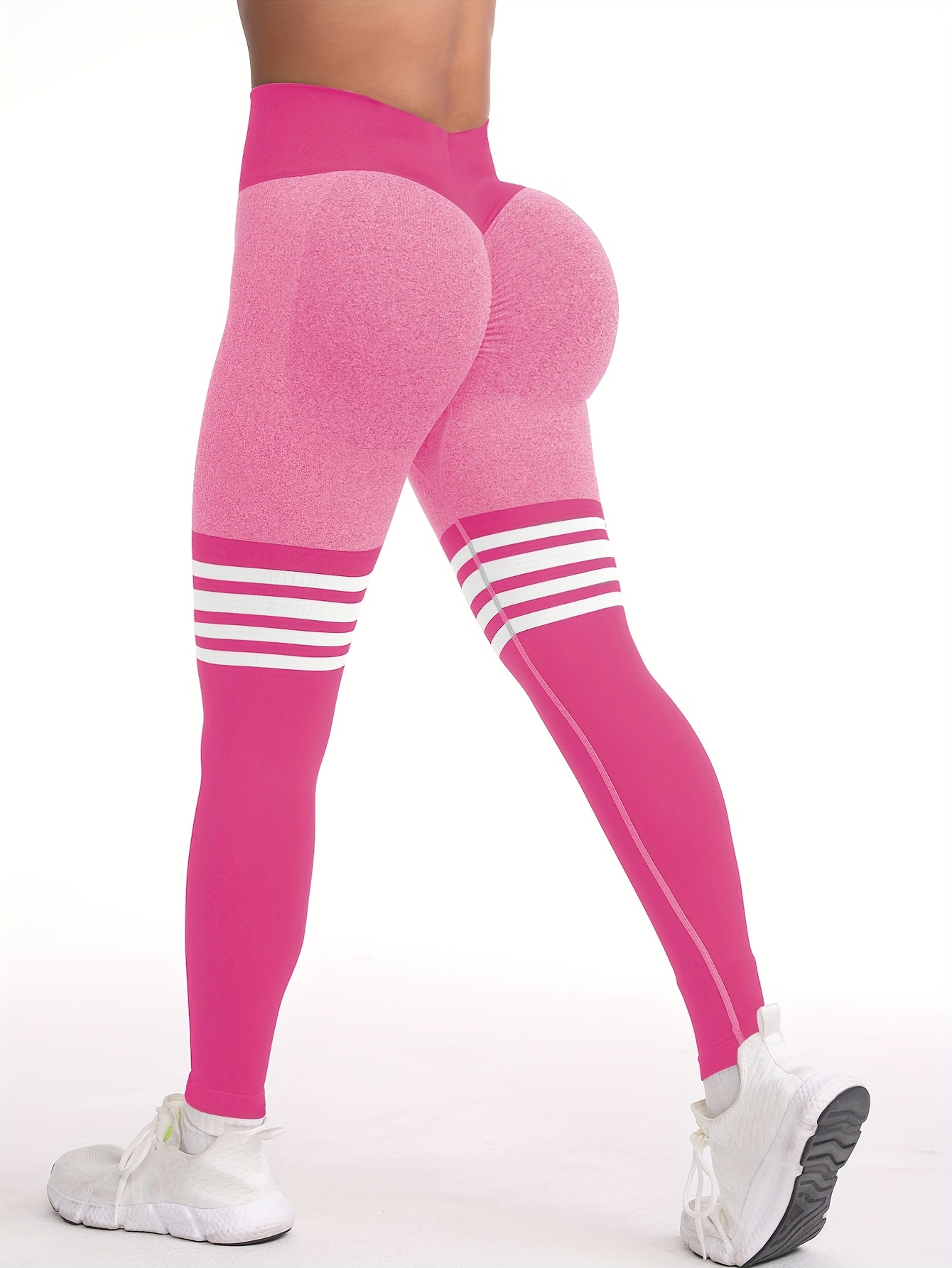 A woman wearing a pink yoga leggings sold by 100 Spartans