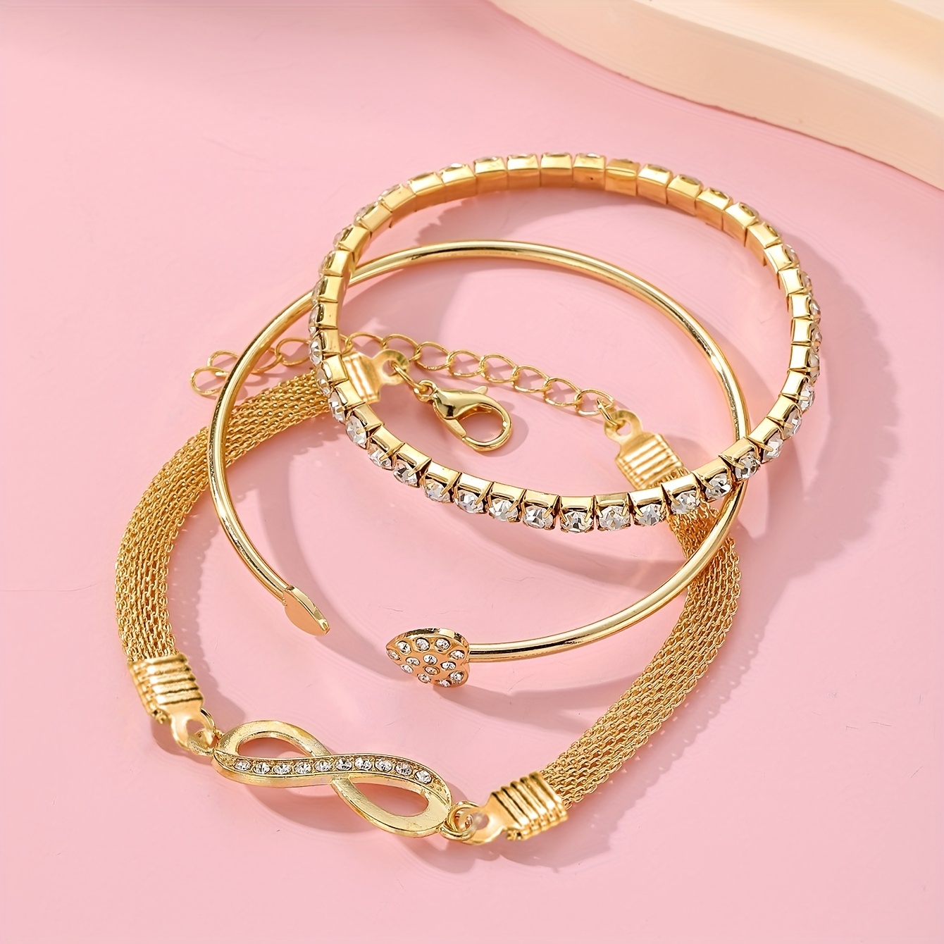 A Set of Three Women'S Bracelets And Bangles Featuring Wireless Symbols And Heart Designs Adorned with Rhinestones.