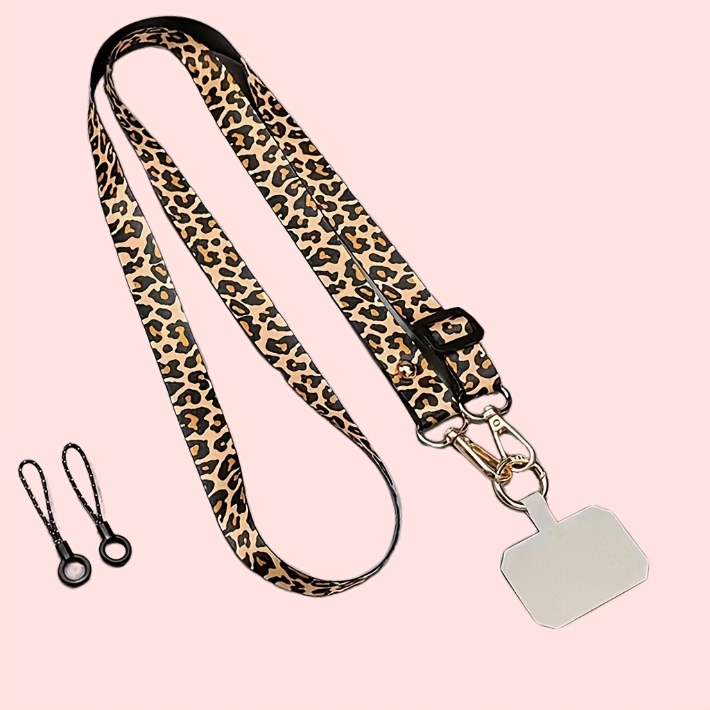 Image of A Leopard Print Phone Lanyard, Featuring A Slim And Stylish Phone Strap, A Long Crossbody Shoulder Strap, And A Wide Neck Strap. The Length Is Adjustable, Worn Crossbody Or Around The Neck