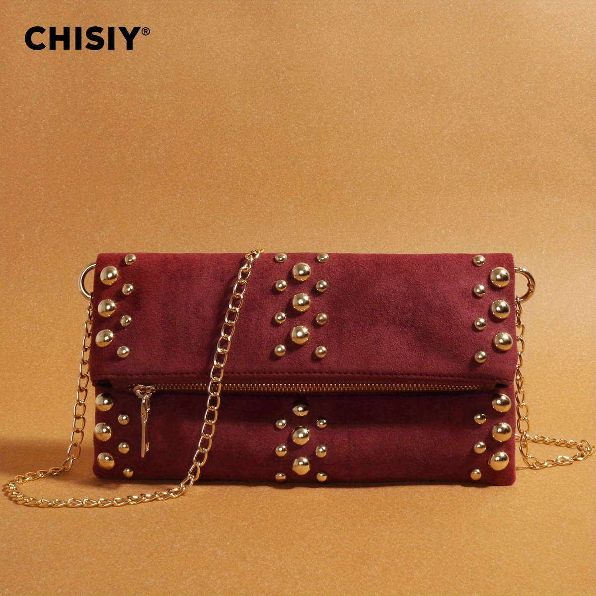 this   burgundy suede chain bag with its   design and     everyones attention the bag is   with golden studs and features a detachable   shoulder strap