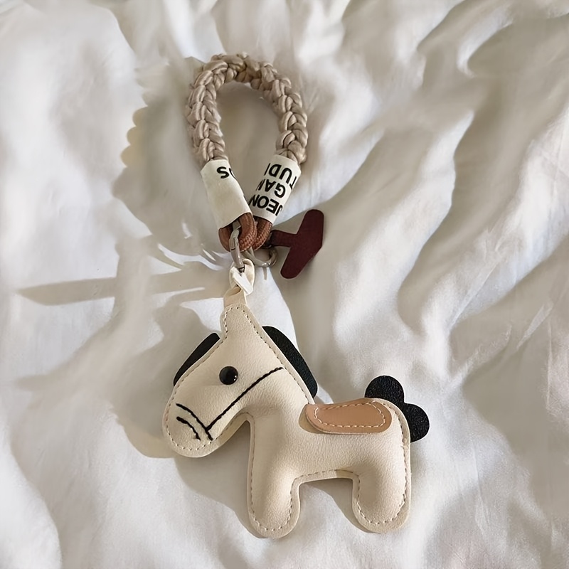 Image of A Pu Horse-shaped Phone Charm With A Faux Leather Pendant And Hand-woven Rope Wrist Strap, Designed Specifically For Women's Phones And Handbags, Featuring A Year Of The Horse Theme