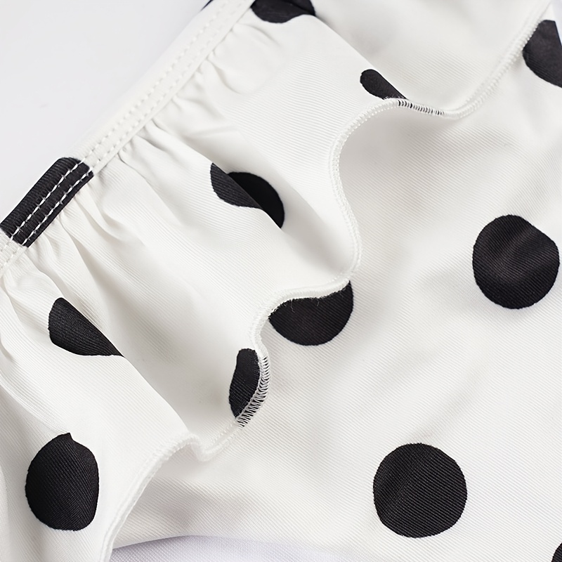 A Beach Vacation Outfit Featuring a Color-Blocked Polka Dot Bikini Set, with a Sexy Tie-Front Crop Top And Ruffled Shorts, Perfect for Seaside Holidays