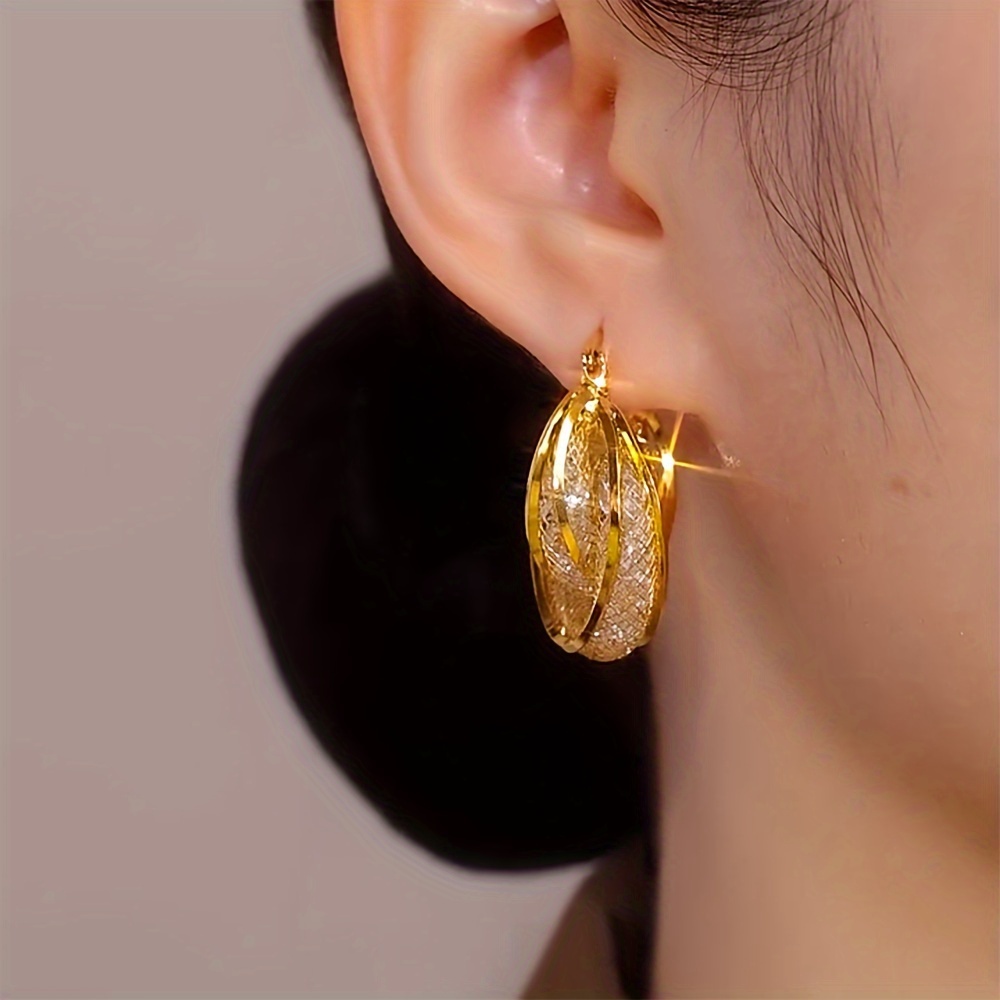 

A Pair Of Girls' Golden Fashionable Hollow Mesh Earrings, Which Exaggerated Temperament And Light Luxury In Women's Jewelry Earring Gifts, Are The Perfect Earring Gifts For Women