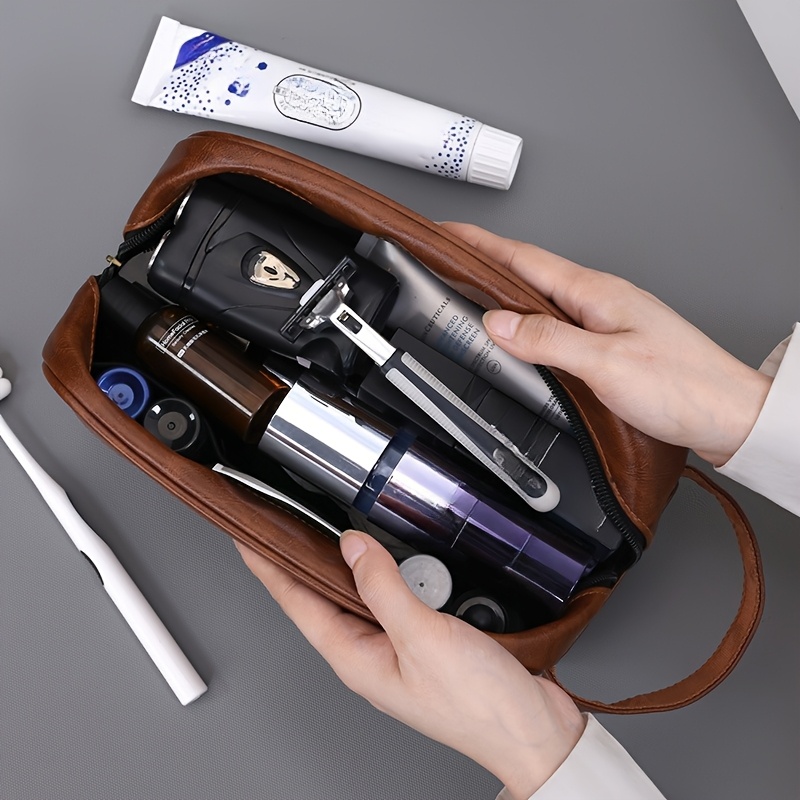 A packed brown leather toiletry bag sold by 100 Spartans.