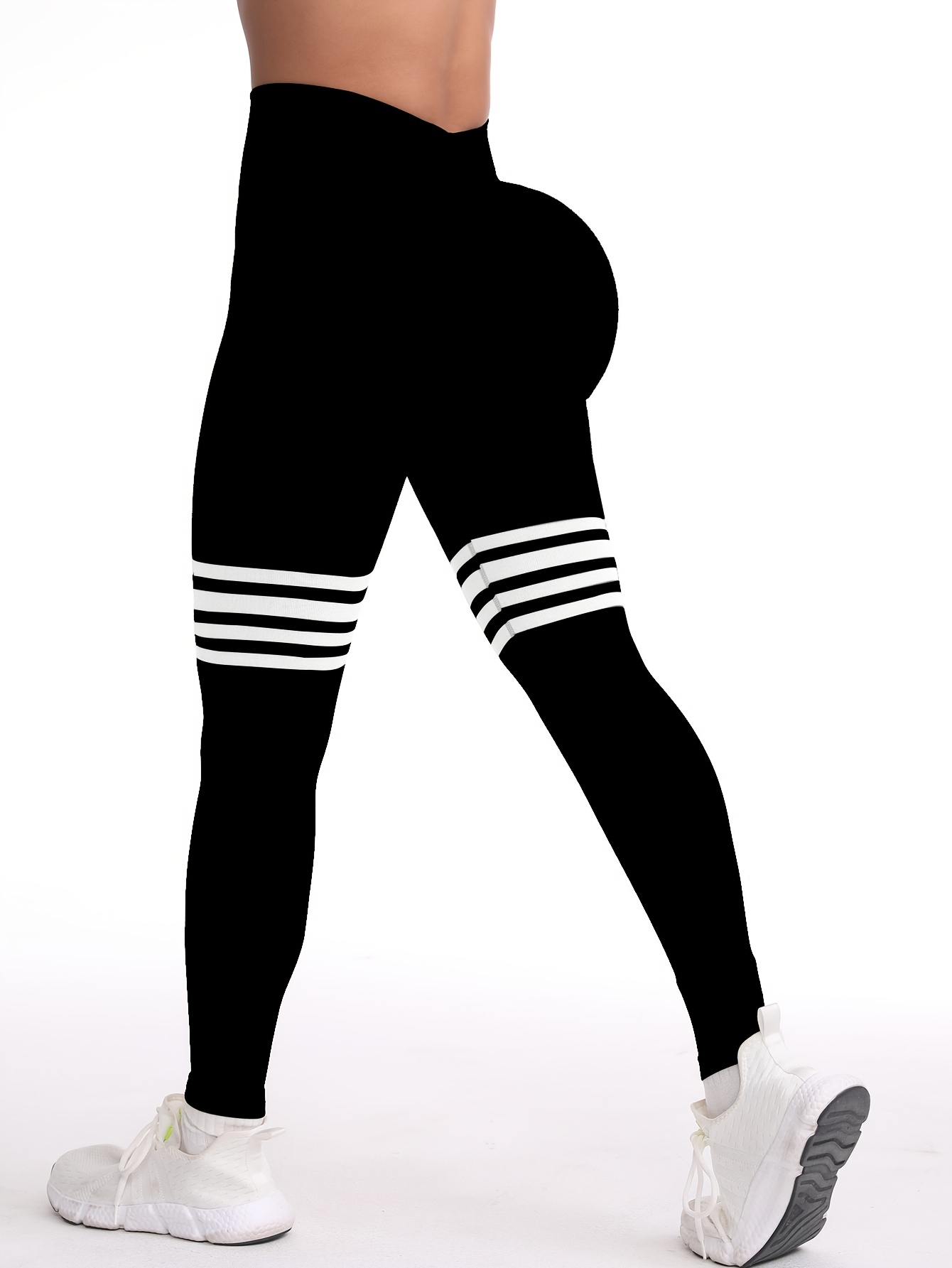 A woman wearing a black yoga leggings sold by 100 Spartans