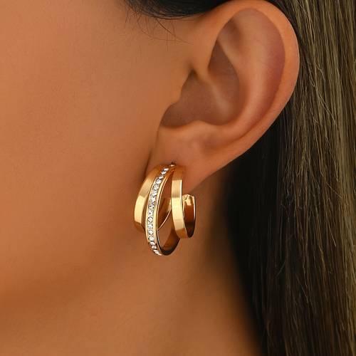 un par de aretes minimalistas para mujer.