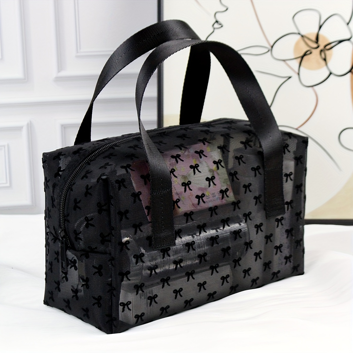 E-shop Eine stilvolle und minimalistische Kosmetiktasche, ausgestattet mit einer schwarzen Samt-Schleife und atmungsaktivem schwarzen Mesh-Material.