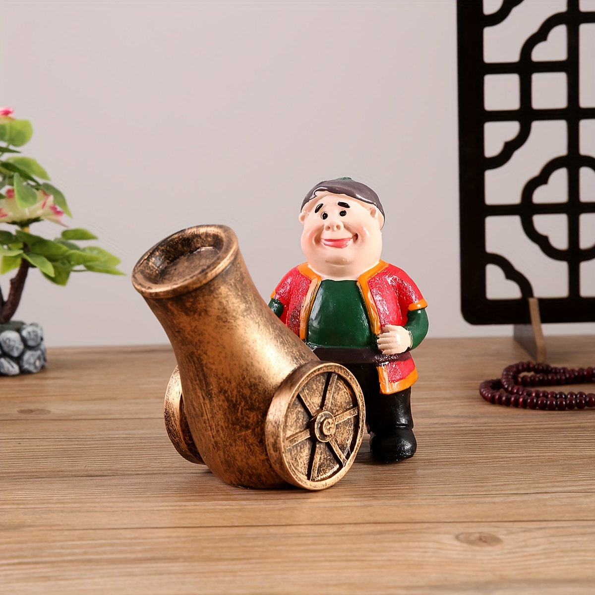a resin figure of a chubby old man with a cannon suitable for decoration during eid celebrations Product details 0
