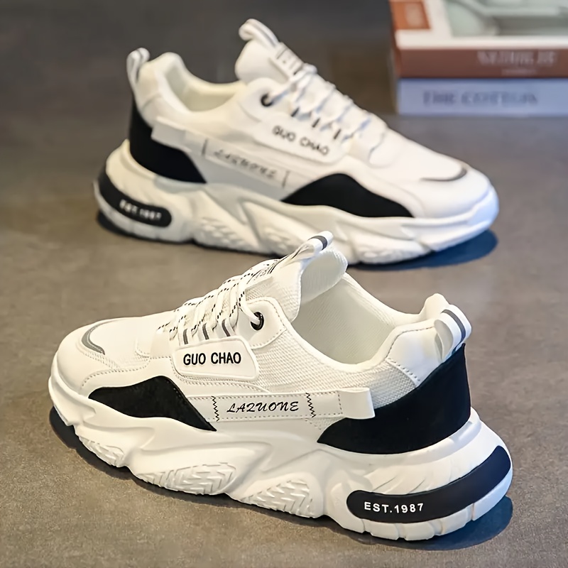 1 par de zapatos de skate versátiles para hombre con agarre fuerte, adecuados para viajes y caminatas al aire libre, comodidad para todas las estaciones, zapatillas bajas con cordones casuales en blanco y negro.