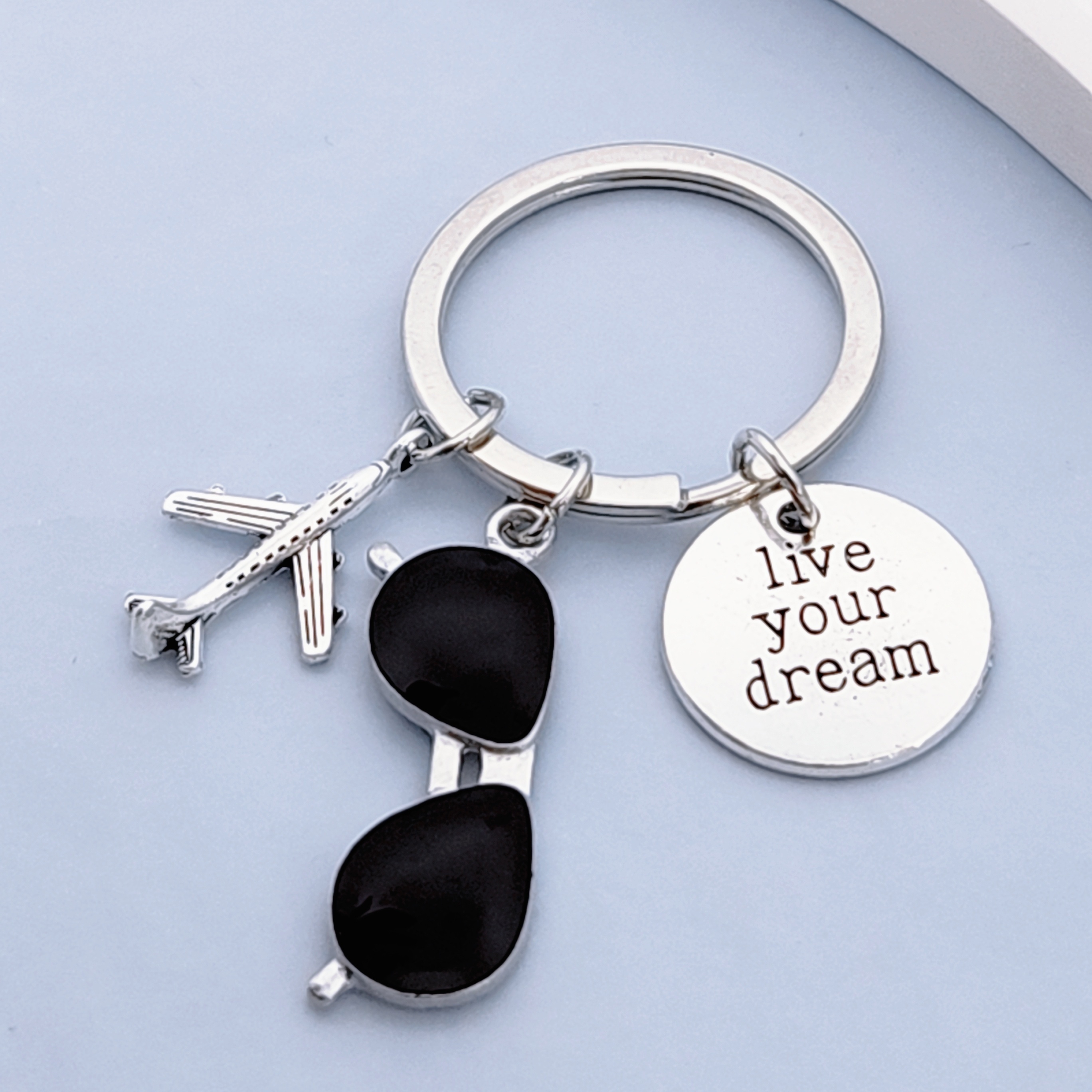 

Western Fashion: Pursue Dreams A Dream Keychain Featuring An , Sunglasses, And A Keychain.