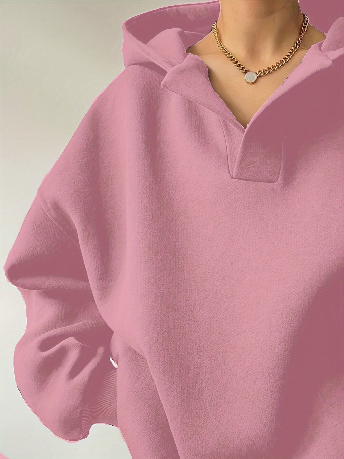 A woman wearing a pink winter hoodie for women sold by 100 Spartans