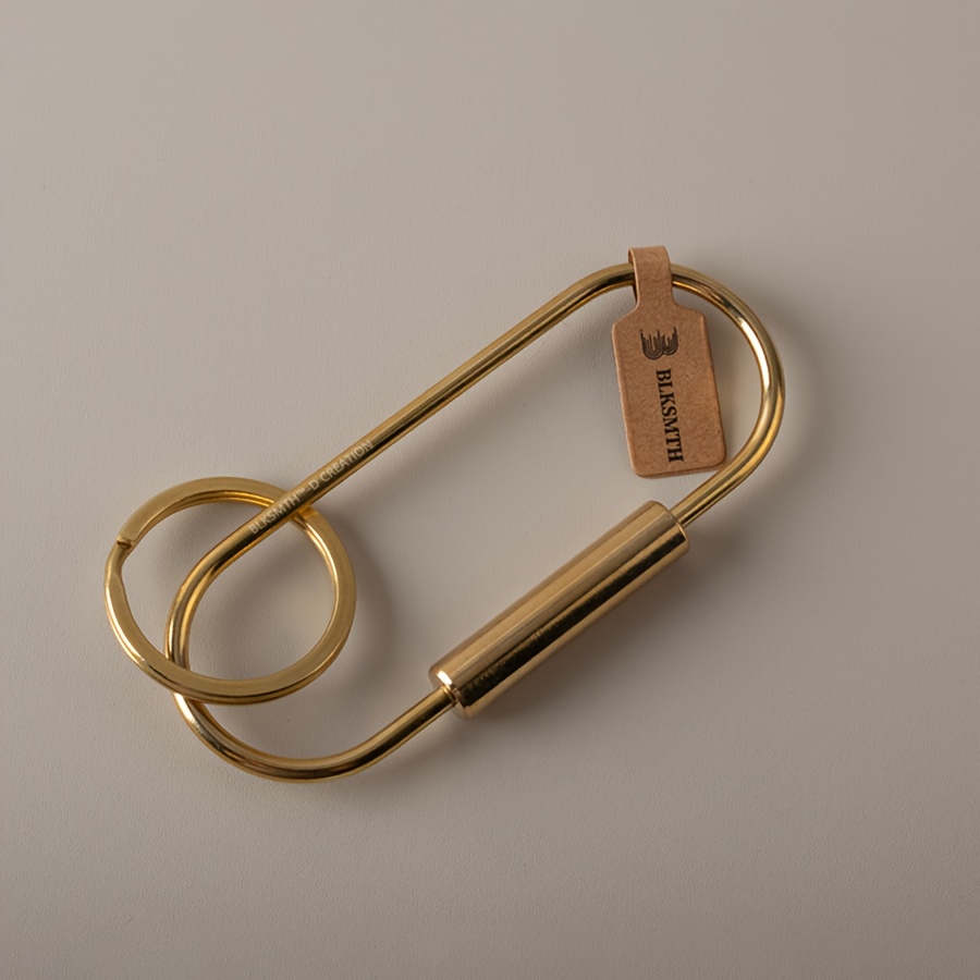 A Brass Pendant From Blksmth Designed Like A Paper Clip.