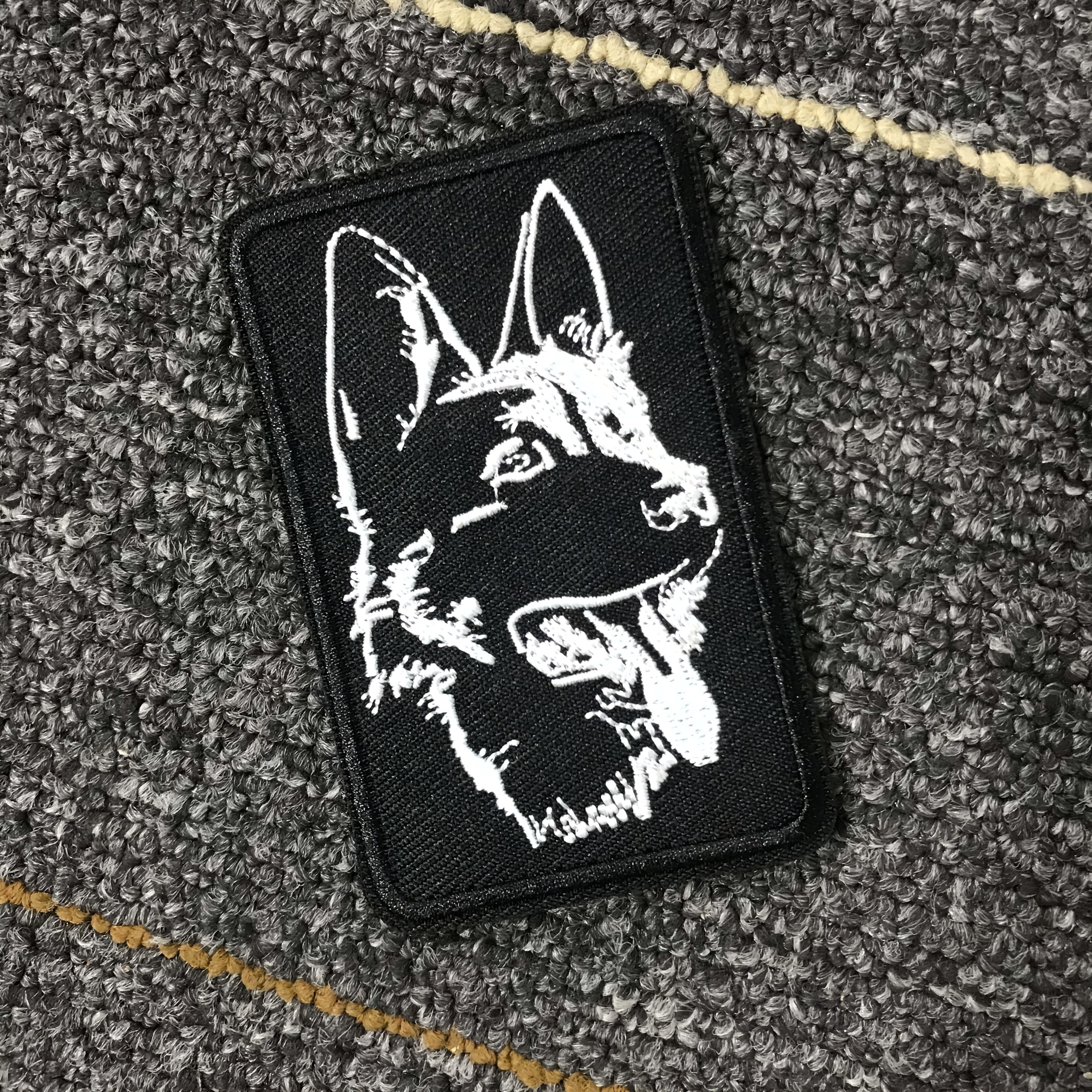 E-shop Bestickter Aufnäher mit Wolfs- Hundekopf auf schwarzem Hintergrund mit weißem Garn, als Klettverschluss gestaltet. Geeignet zum Dekorieren von