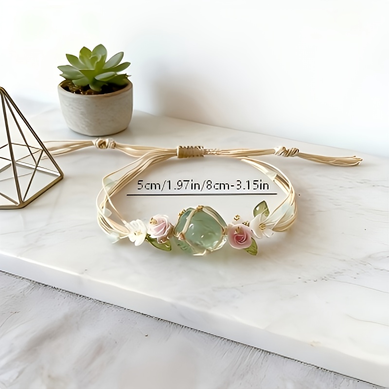 E-shop Ein verstellbares, handgefertigtes, gewebtes Armband im Boho-Stil mit grünen Kristallen und floralen Anhängern, mit Macaron-Pink und weißen