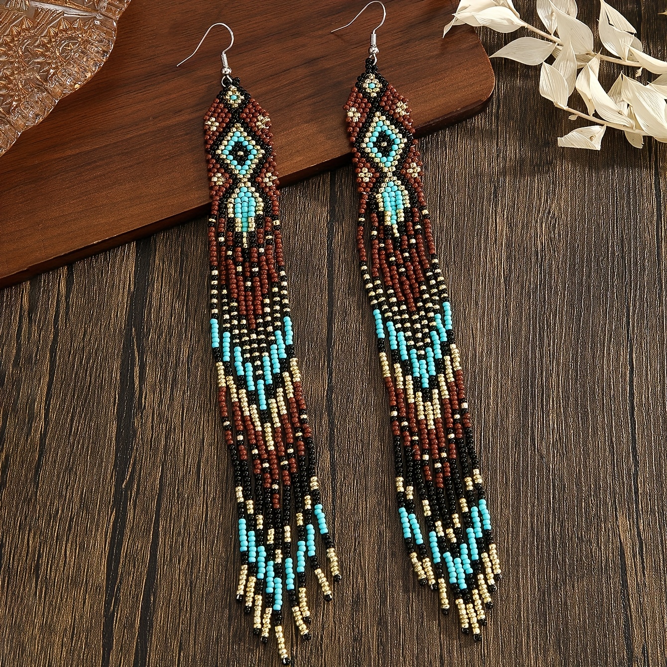 E-shop Handgefertigte lange Perlenohrringe für Damen im Bohemian-Stil mit einem vintage-ethnischen Design. Die unregelmäßige, diamantförmige Quaste