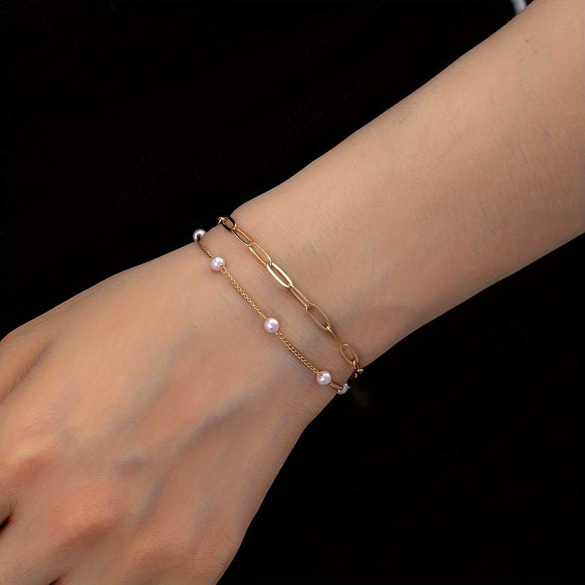 

Un bracelet à chaîne double couche avec des perles fausses, incarne un de l'élegance et de la luxure, pour un accessoire unique et haut de gamme.