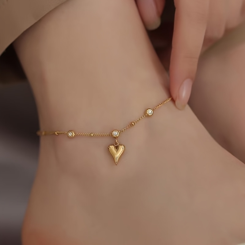 

A Stainless Steel Anklet Featuring A Vintage French Style With Embedded Glass Decorations And A Heart-shaped Pendant Is Women To Wear While .