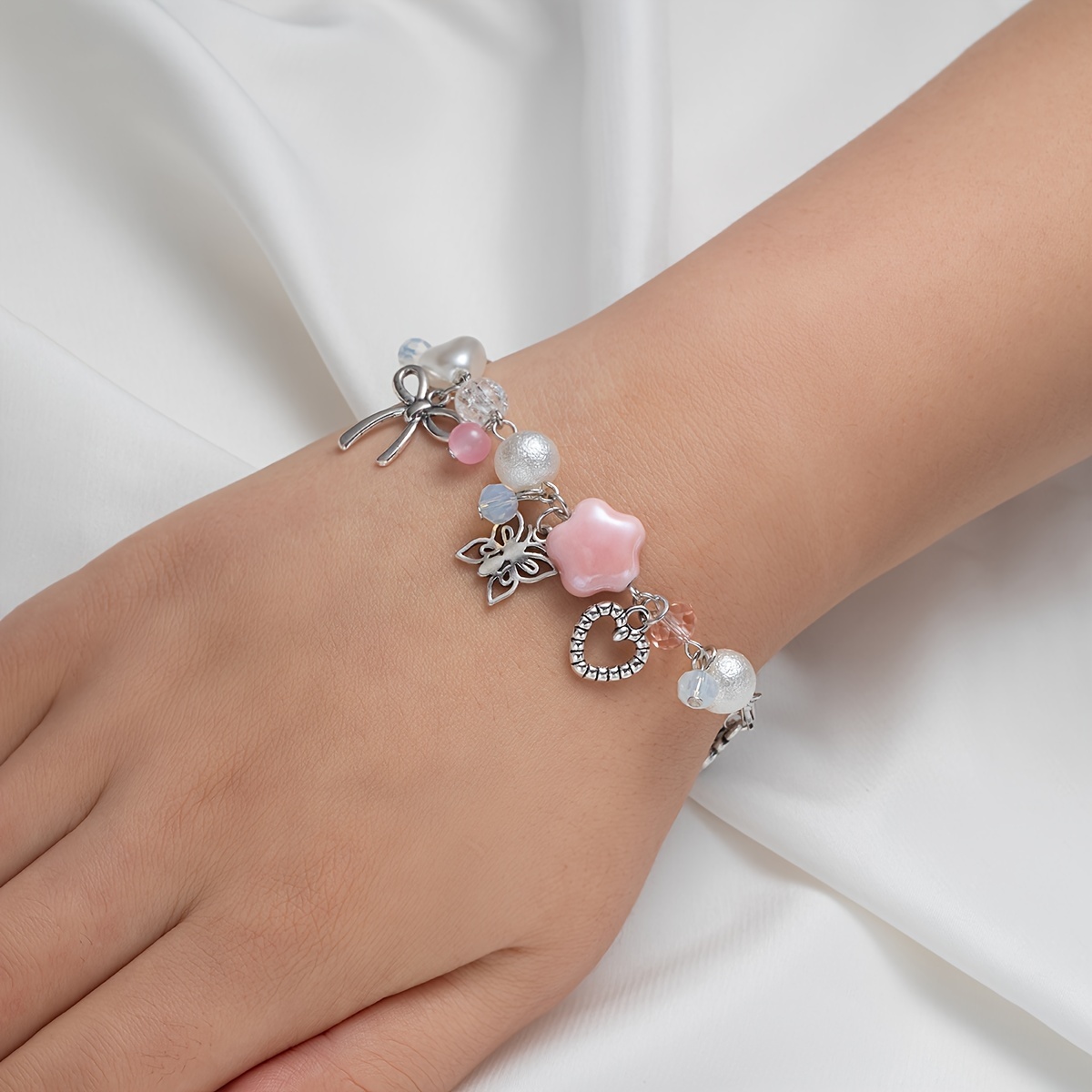 

Bracelet plein de charme : orné de pendentifs nœud, cœur, rose et papillon, parfait pour un usage quotidien ou en tant qu'accessoire de vacances