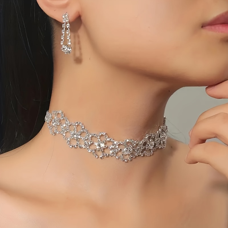 

A Beautiful Jewelry Set With A Flower Choker Necklace And Dangling Earrings Adorned With Sparkling Rhinestones, Exuding Elegance.