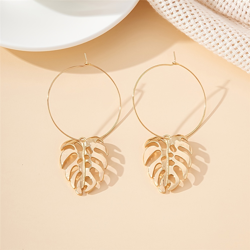 

A Pair Of Minimalist Golden Hollow Leaf Earrings Suitable For Dates, Dinners, And .