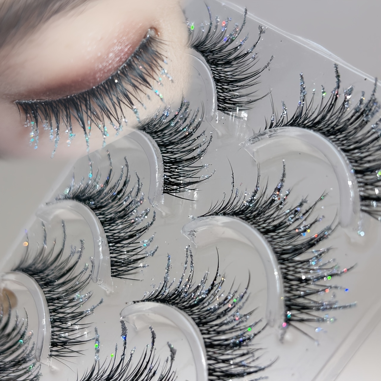 Image of A Box Of 5 Pairs Of Thai-style Crushed False Eyelashes, Dense, Crisscrossed, Elongated, With A Glass-crushed Shimmer For A Wild, Natural Festival Look