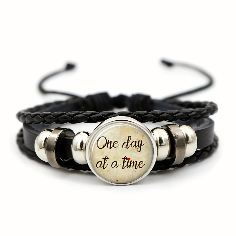 TEMU Bracelet noir pour homme, 1 pièce, avec un insigne rond sur fond beige, le texte cursif noir « One Day » et des touches de cœurs rouges. Motif