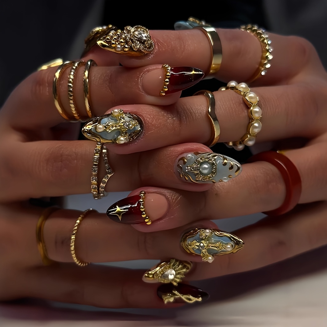 Image of A Set Of 24 Medium-length Almond-shaped Press-on Nails In Vintage Design, Featuring Golden Crosses, Pure-desire, Sparkling Golden Glitter, And . Suitable For And. The Box Includes A File