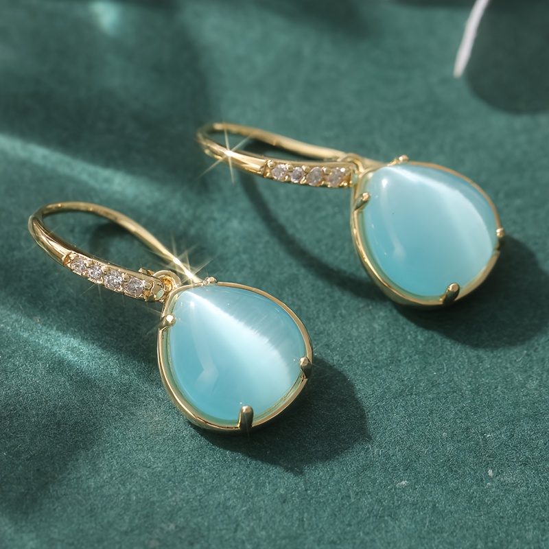 E-shop Stylische und prachtvolle blaue Wassertröpfchen-Ohrringe aus goldenem Kupfer mit funkelnden synthetischen Zirkonien. Diese hochwertigen Anhänger