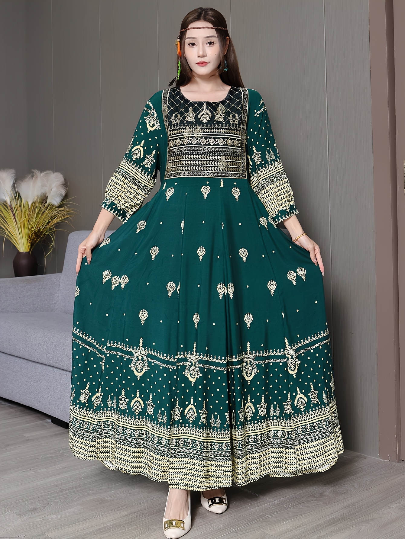 A stunning emerald green maxi dress with intricate embroidery shown on a model The dress has a flowing silhouette and full skirt