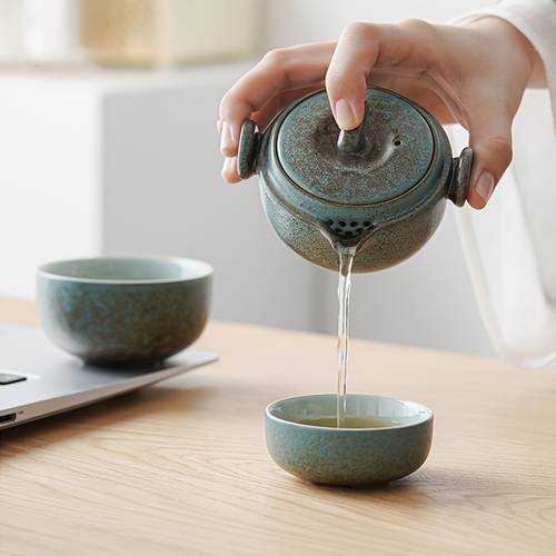 a portable japanese outdoor tea set for travel including a small teapot and two ceramic cups