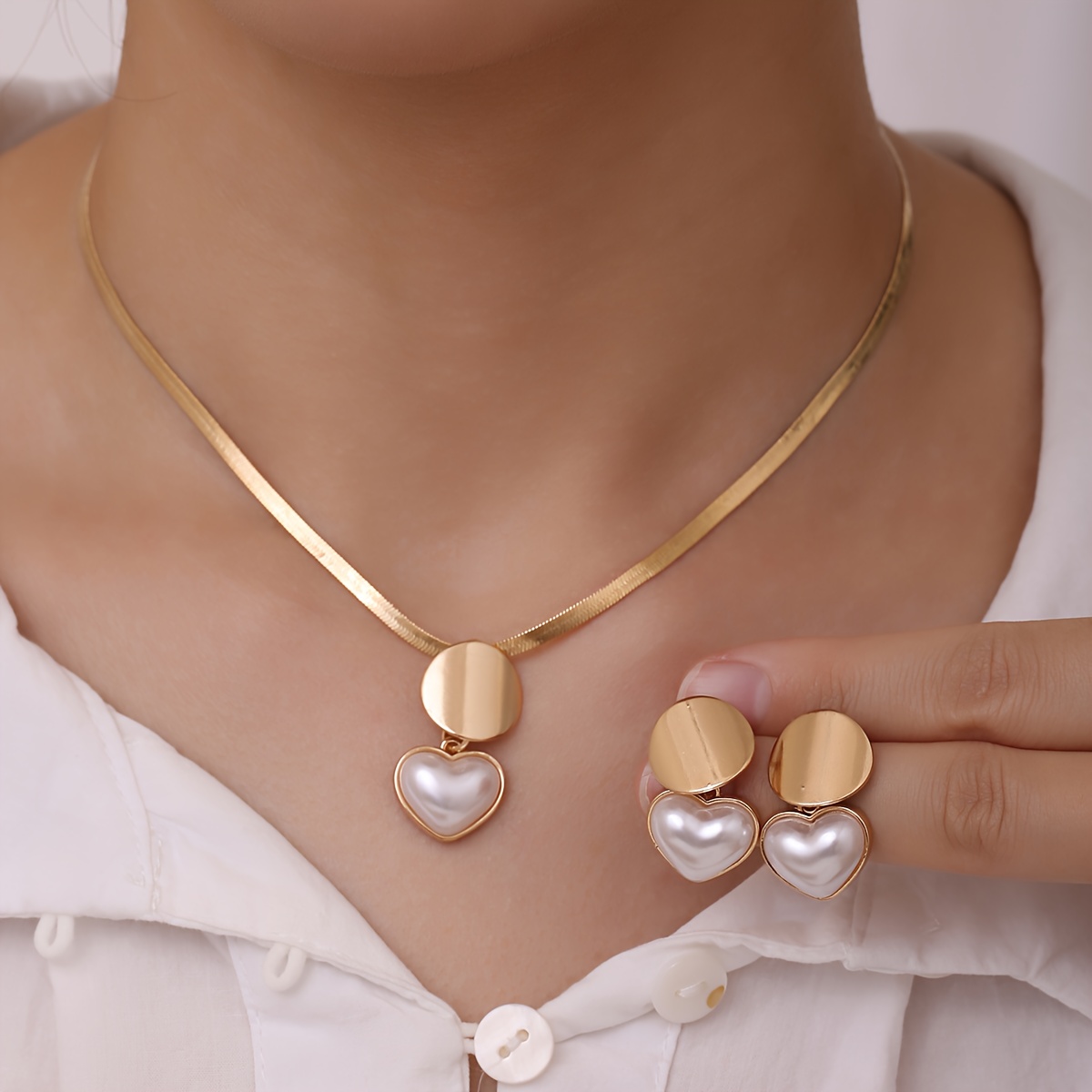 Un nuevo y elegante conjunto de collar y aretes en forma de corazón para mujer, que incluye un colgante geométrico dorado que adorna con gracia el clavícula. Este conjunto de joyería de estilo francés vintage es un regalo perfecto para damas en ocasiones como citas.