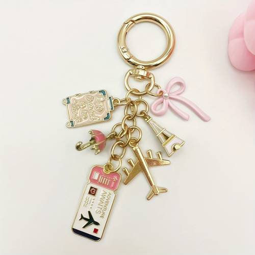 an elegant bow travel keychain pendant in of an airplane with diy decorations such as suitcases boarding passes and tower hanging on it and a multi functional bag pendant