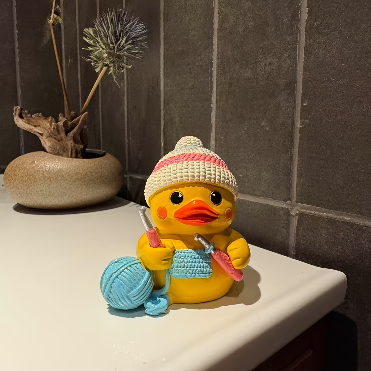 niedliche strickente harzfigur, gelbe entenstatue mit häkelmütze und garn, handgefertigte harzente deko für den schreibtisch, skurriles geschenk für strickliebhaber und bastelfreunde