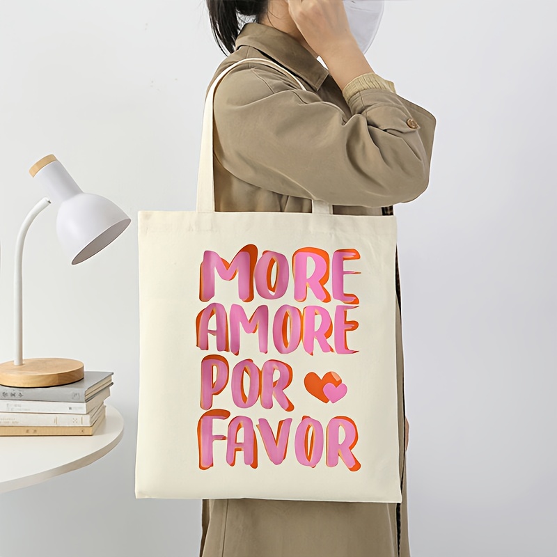 E-shop Eine wiederverwendbare Tragetasche mit 'MORE AMORE ' - eine robuste Einkaufstasche aus Polyester mit einem pink-orangen Buchstaben-Design, für