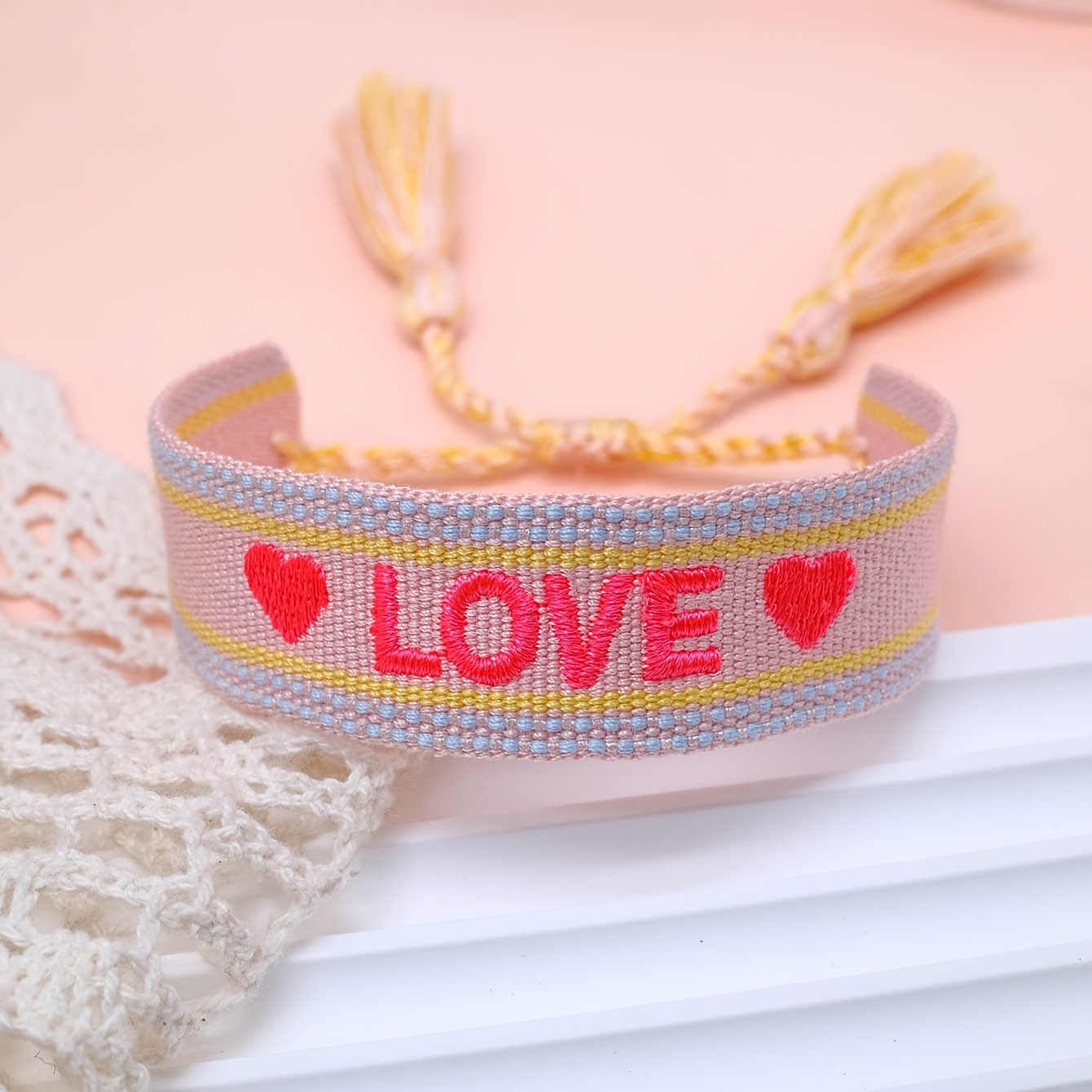 Image of A Handcrafted Vintage Tassel Bracelet With Embroidered Letters And Hearts, Perfect As A Gift For A Travel-themed Wedding Party