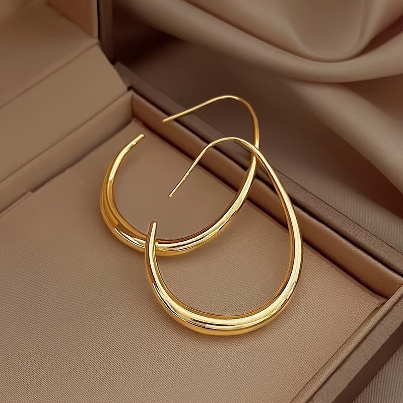 

A Pair Of Minimalist Chic Teardrop-shaped Hoop Earrings, Exuding Elegance, Ladies To Wear To Parties And Vacations.