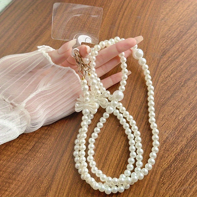 

A Delicate Necklace With A White Pearl And A Small Butterfly-shaped Bow