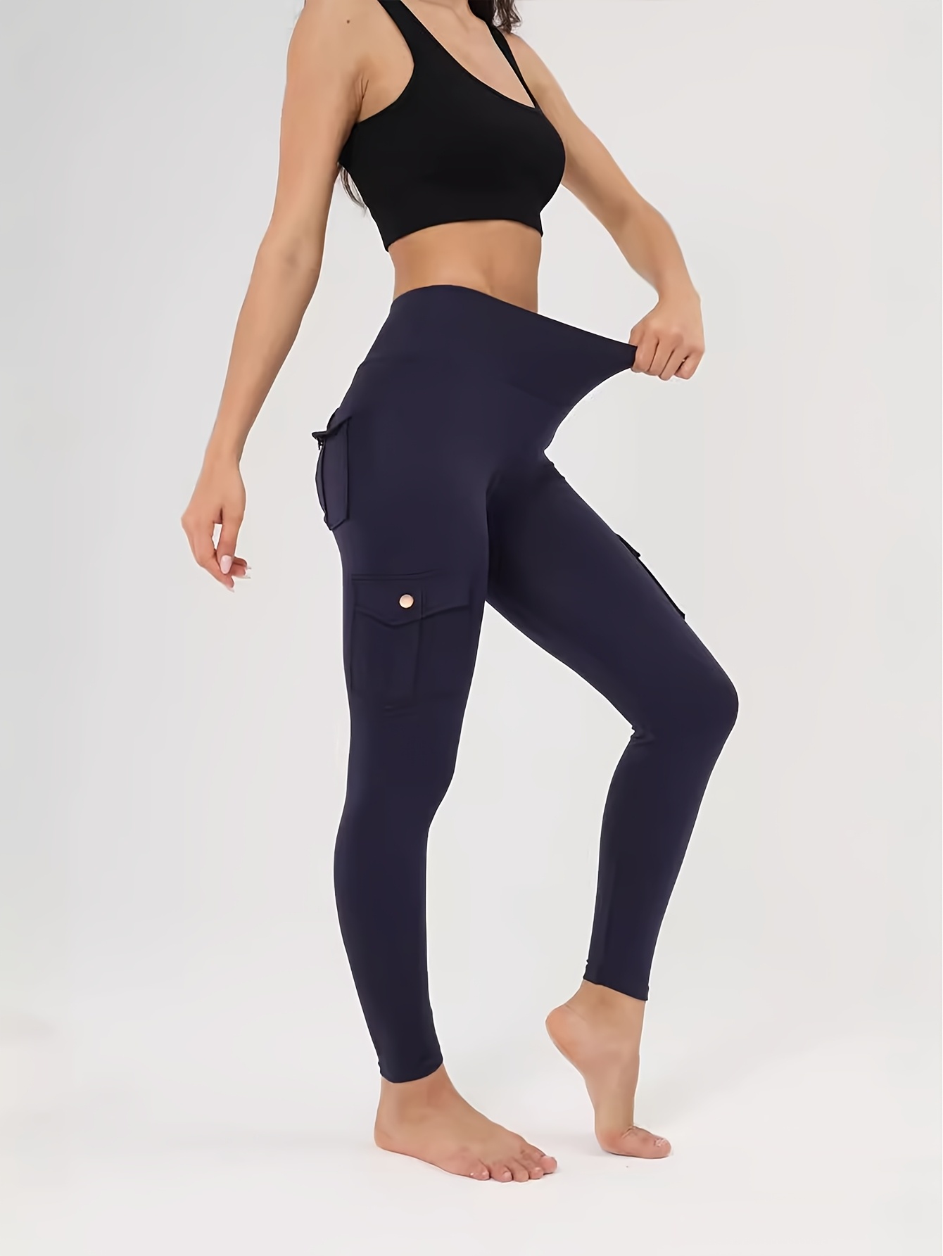A woman wearing a blue yoga leggings sold by 100 Spartans
