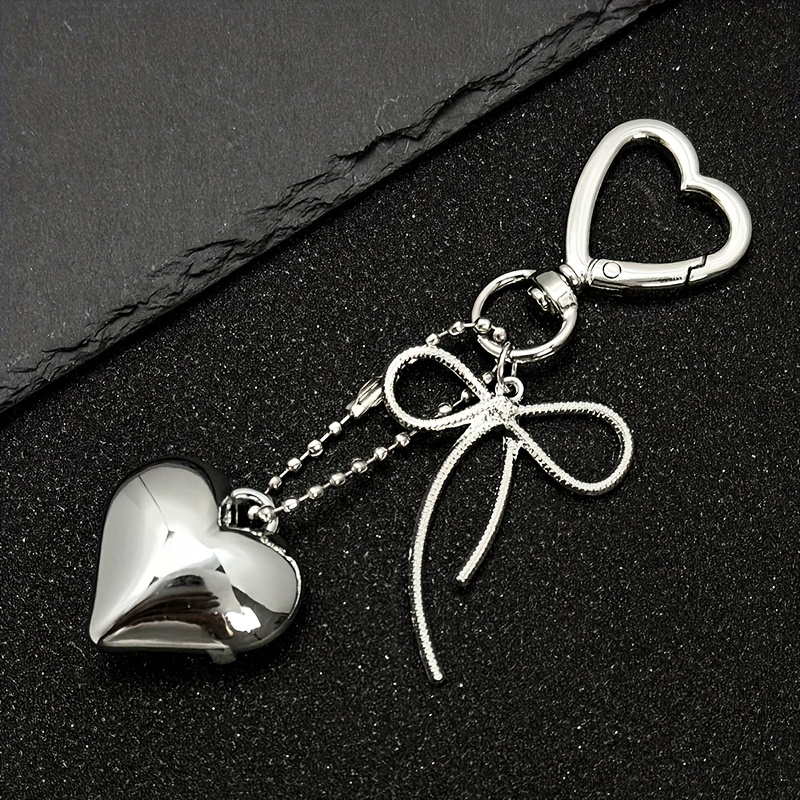 

A 2025 Heart-shaped Keychain With A Peach Heart And Bowknot, Which Used As A Decoration For Bags Or As A Lovely Keychain Ring For Gifts.